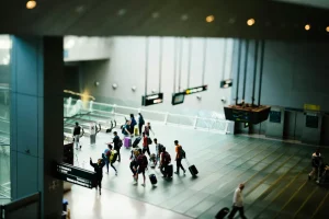 A group of people approaching the top of an escalator at an airport